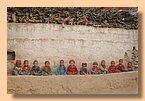Die kleinen Trapas sitzen in einer Reihe vor der Klostermauer.jpg