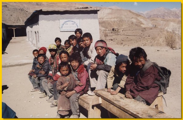 Schuljungen waermen sich in der Sonne vor derm Schulhaus.jpg