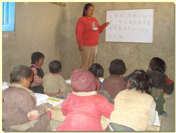 Die Lehrerin Nyingda erklaert Buchstaben.JPG
