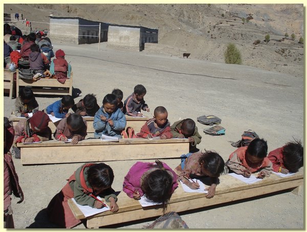 Kinder tief gebeugt ueber Pruefungsboegen.JPG