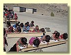 Kinder tief gebeugt ueber Pruefungsboegen.JPG
