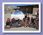 Die Kinder warten vor dem umgestuelpten Solarkocher auf das Mittagessen.JPG