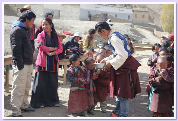 Tenzin Namdol verteilt Sssigkeiten an die Kleinen.JPG