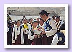 Der Lehrer Tenzin Namdrol verteilt Süssigkeiten.JPG